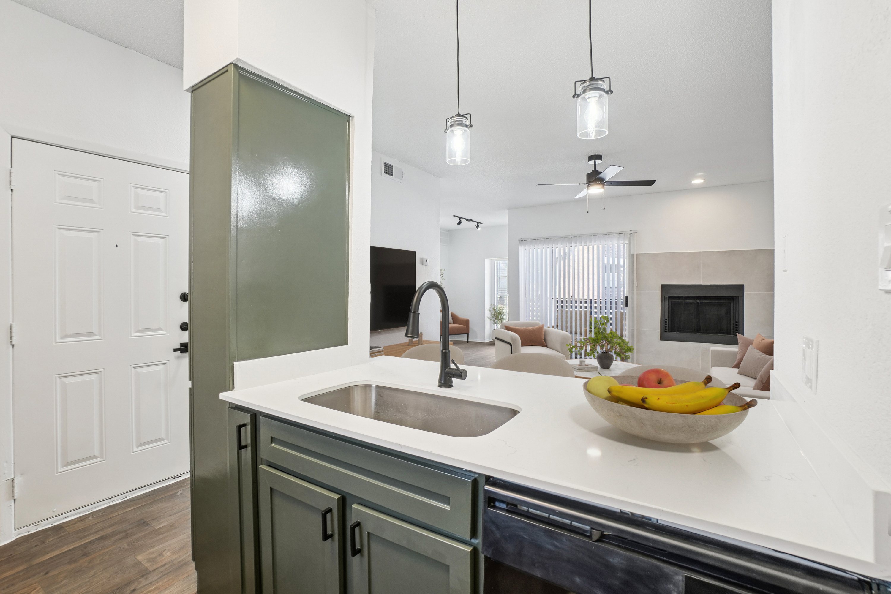A kitchen with a bowl of fruit on the counter.